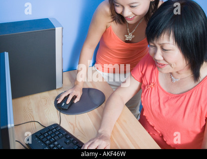 Portrait d'une jeune femme et sa mère à l'aide d'un ordinateur et souriant Banque D'Images