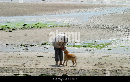 Young woman Playing with dog on beach Banque D'Images