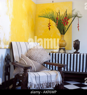 Striped jeter sur un fauteuil en bois au coin de séjour ci-dessous grand jaune double abstrait peinture Banque D'Images