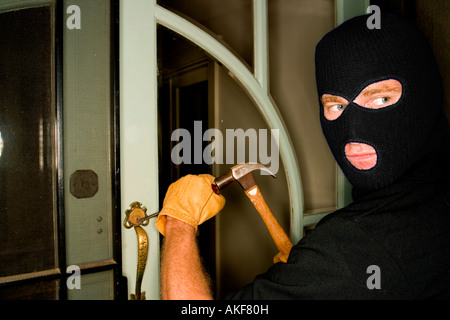 Un cambrioleur de voler une maison portant une cagoule. Banque D'Images