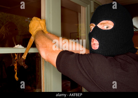 Un cambrioleur de voler une maison portant une cagoule. Banque D'Images