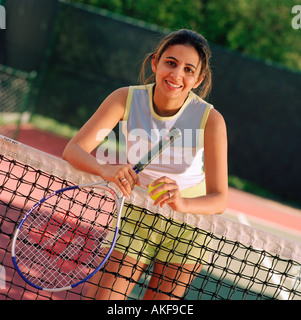 Tennis player leaning on net Banque D'Images