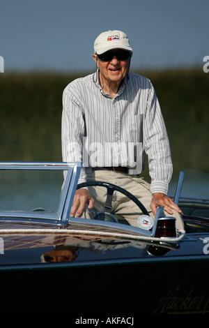 Une happy senior man sitting dans son bateau. Banque D'Images