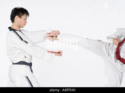 Close-up of a Mid adult man le kickboxing avec un jeune homme Banque D'Images