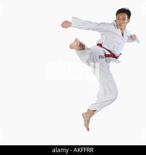 Close-up of a young man jumping et pratiquer les arts martiaux Banque D'Images