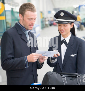 Businessman montrant un billet d'avion à une femme pilote Banque D'Images