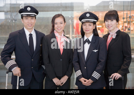 Portrait d'un homme et une femme pilote debout avec deux femmes, l'équipage de cabine Banque D'Images