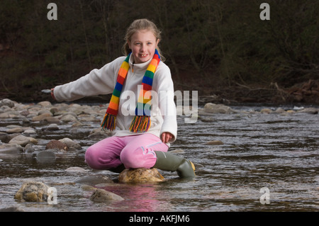 Fille, 10, une pierre sur une rivière, Ecosse Banque D'Images