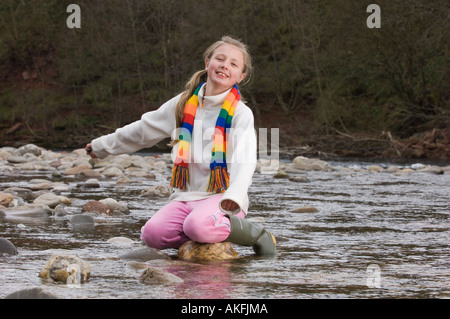 Fille, 10, une pierre sur une rivière, Ecosse Banque D'Images