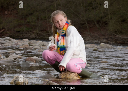 Fille, 10, une pierre sur une rivière, Ecosse Banque D'Images