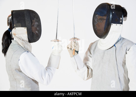 Portrait d'un homme et une femme portant des masques et la tenue des feuilles d'escrime Banque D'Images