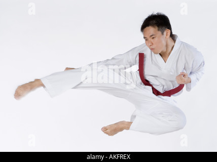 Close-up of a young man jumping et pratiquer les arts martiaux Banque D'Images