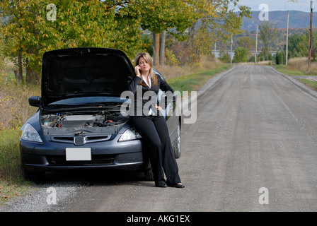 Businesswoman assis sur son automobile en panne sur le côté de la route Appel à l'aide Banque D'Images