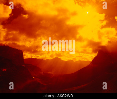 Coucher du soleil illumine le ciel au parc national Glacier du Montana la création d'une aura dorée sur la scène spectaculaire de montagne Banque D'Images