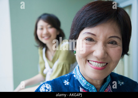 Portrait of a senior woman smiling avec sa petite-fille debout derrière elle Banque D'Images