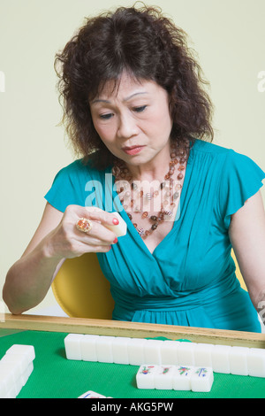 Senior woman jouer mahjong Banque D'Images