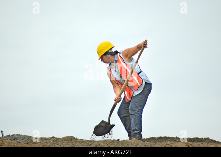 Chantier de construction routière, avec les jeunes femmes qui travaillent fort à la pelle Banque D'Images