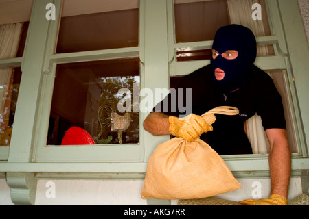 Un cambrioleur de voler une maison portant une cagoule. Banque D'Images