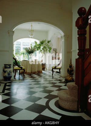 Vinyle noir et blanc à parquet en damier hall traditionnel avec vue sur la salle à manger par arch Banque D'Images