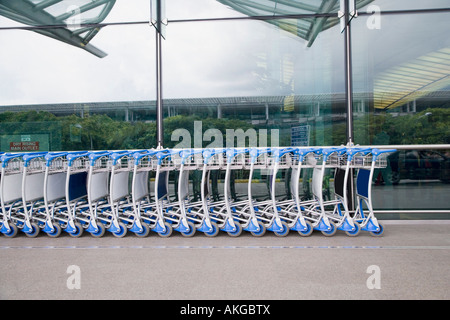 Chariots à bagages dans une rangée en dehors d'un aérodrome Banque D'Images