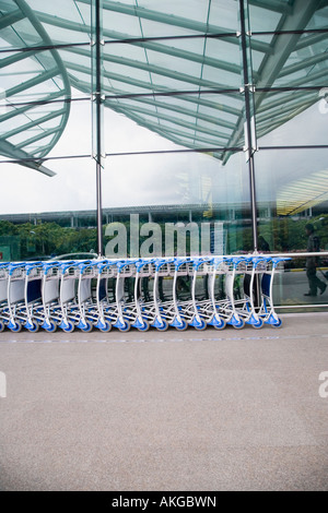 Chariots à bagages dans une rangée en dehors d'un aérodrome Banque D'Images