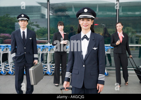 Portrait d'une femme pilote avec un pilote et deux équipages de cabine debout dans l'arrière-plan Banque D'Images