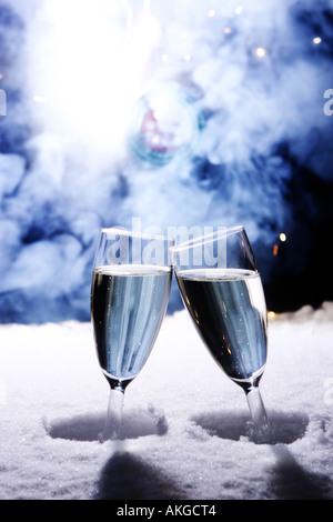 Deux verres de champagne dans la neige clink verres pour nouvel an à sylvester firework en arrière-plan Banque D'Images