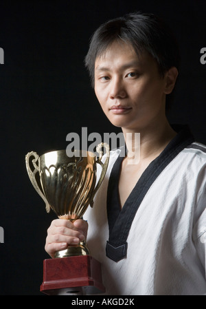 Portrait d'un jeune homme tenant un trophée Banque D'Images