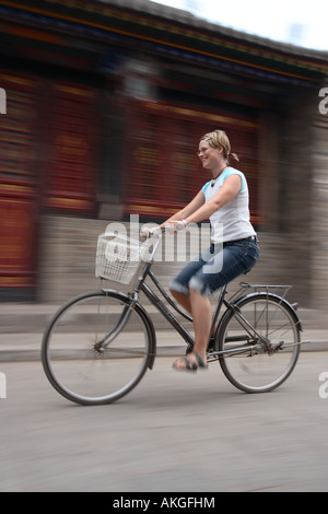 Une des tours touristiques son vélo à Pingyao, Chine dans une image qui montre l'effet de flou comme elle chevauche vers le bas par l'ancienne ville en louant un vélo Banque D'Images