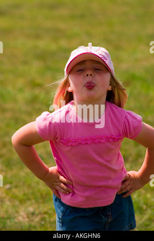 Quatre ans, fille, vêtue de rose t shirt et les coller sa langue out