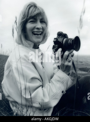 Candid portrait of woman holding camera NIKON. Photo en noir et blanc, 1980. Banque D'Images