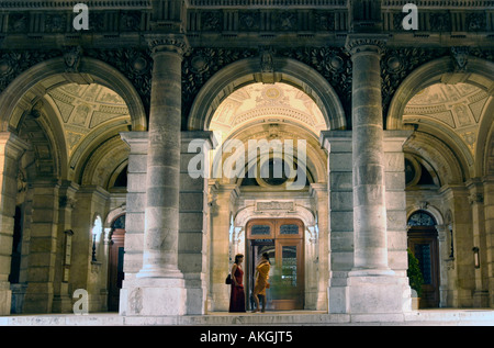 Deux femmes ayant une conversation sous les arcades de l'Opéra de nuit Budapest Hongrie Banque D'Images