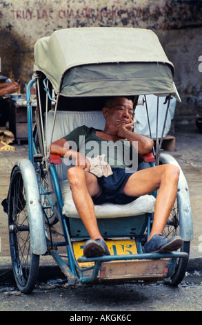 Un vietnamien pedicab driver prendre une sieste Banque D'Images