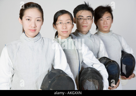 Portrait de deux hommes et deux femmes tireurs holding masques Banque D'Images