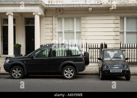 Voiture électrique Reva G Wiz stationné à côté d'un 4x4 sur une rue de Londres au Royaume-Uni Banque D'Images