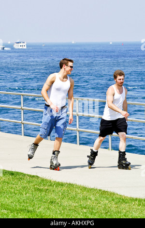 Deux hommes adultes le patin à roues alignées le long des quais de la rivière St Clair Michigan MI Banque D'Images