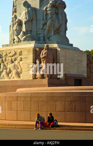 Les gens assis au monument de la liberté centre de Riga Lettonie UE Banque D'Images