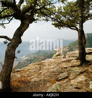 Woman talking on mobile phone sur le haut de gamme de montagne chihuahua Mexique copper canyon Banque D'Images