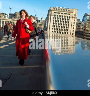 Tôt le matin, les navetteurs Londres crossing bridge femme en manteau rouge soleil ciel bleu Banque D'Images