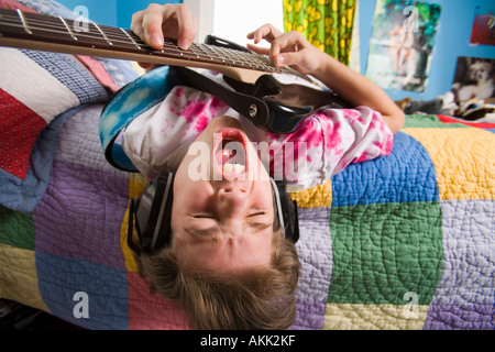 Garçon qui joue de la guitare et chant Banque D'Images