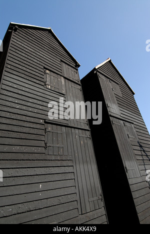Ces boutiques net et distinctif haut historique à bord météo cabanes goudronnées noir sur le bord de la plage ont été utilisés pour sécher fishi Banque D'Images