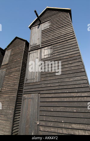 Ces boutiques net et distinctif haut historique à bord météo cabanes goudronnées noir sur le bord de la plage ont été utilisés pour sécher fishi Banque D'Images