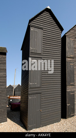 Ces boutiques net et distinctif haut historique à bord météo cabanes goudronnées noir sur le bord de la plage ont été utilisés pour sécher fishi Banque D'Images
