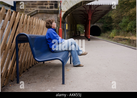 Femme en attente d'un train à la gare de Cromford Derbshire dans le Peak District Banque D'Images