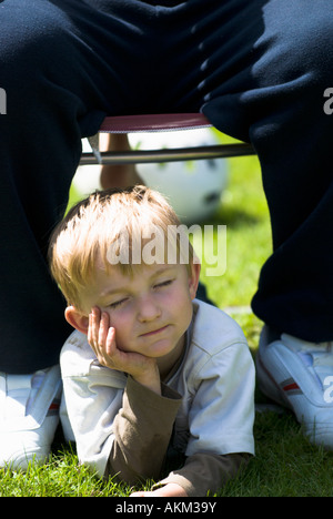 Jeune garçon en fumant en cours pour prendre du temps sous les pieds de son père Banque D'Images