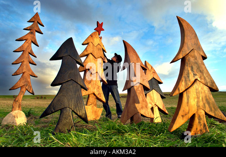 Artiste Johnny Woodford avec les arbres de Noël en bois réutilisables il sculpte à partir de l'orme recyclé Banque D'Images