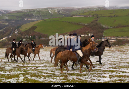 Adeptes de chasse à cheval à la poursuite d'Llangeinor Hunt sur colline au-dessus de la neige près de Bridgend Blackmill South Wales UK Banque D'Images