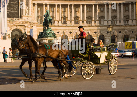 Fiaker passant le Neue Hofburg pendant une visite de la ville Vienne Autriche Banque D'Images