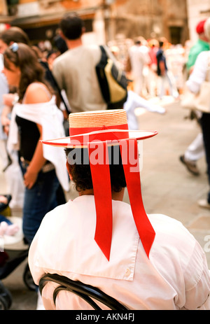 Assis gondolier avec chapeau de paille et des rubans rouges Venise Italie Banque D'Images