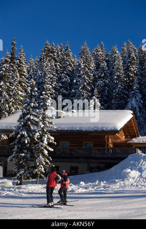 Deux skieurs debout à côté d'une maison l'Amade Ski Schladming Styrie Autriche Banque D'Images